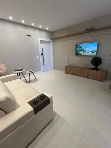 Il comprend un salon doté d'un canapé et d'une télévision à écran plat. dans l'établissement Apto em Porto Belo SC 2 suítes para 7 pessoas, à Porto Belo