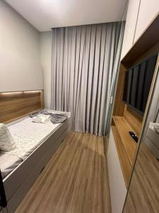 ein kleines Schlafzimmer mit einem Bett und einem Fenster in der Unterkunft Apto em Porto Belo SC 2 suítes para 7 pessoas in Porto Belo
