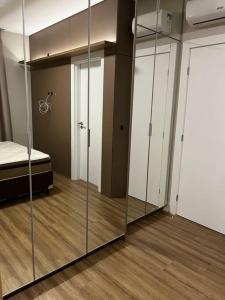 ein Zimmer mit Glastüren und ein Schlafzimmer mit einem Bett in der Unterkunft Apto em Porto Belo SC 2 suítes para 7 pessoas in Porto Belo
