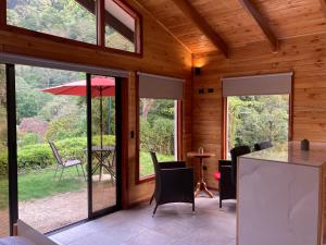 eine Küche und ein Esszimmer eines Hauses mit Glasschiebetüren in der Unterkunft Los Lagos Lodge in San Gerardo de Dota