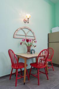 a table with four chairs and a vase of flowers on it at Sea&stone Apartment in Haifa