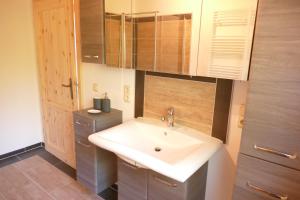 ein Badezimmer mit einem weißen Waschbecken und einem Schrank in der Unterkunft Ferienhaus Förster I in Friedrichsbrunn