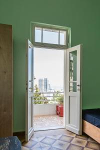 Zimmer mit einer offenen Tür und Stadtblick in der Unterkunft Sea&stone Apartment in Haifa