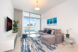 een woonkamer met een bank en een tv bij LUX Opulent Island Suite Burj Khalifa View 7 in Dubai