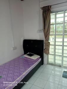 een klein bed in een kamer met een raam bij SP 3 Homestay Kuranji Kota Marudu Sabah Malaysia in Kampong Sorosob