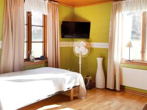 ein Schlafzimmer mit einem Bett und einem TV an der Wand in der Unterkunft 5 person holiday home in BRASTAD in Brastad