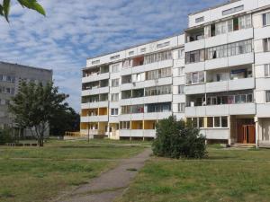 ein Apartmenthaus mit einem Rasenplatz davor in der Unterkunft Dzīvokļi Dunikas ielā 1 in Liepāja
