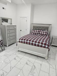 biała sypialnia z łóżkiem i komodą w obiekcie Home away from Home w mieście Leicester