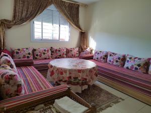 sala de estar con sofá y mesa en Maison de vacances en Ifrane