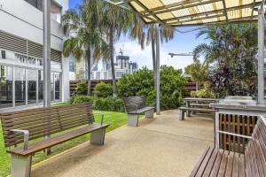 dois bancos sentados num pátio com vista para a cidade em High-Floor 2-Bed CBD Unit With Views & Amenities em Brisbane