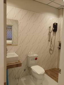ein Bad mit einem WC und einem Waschbecken in der Unterkunft โรงแรมควีนส์ (Queen) in Ban Tha Kham
