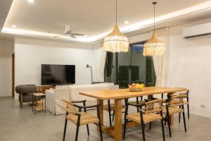 - un salon avec une table et des chaises en bois dans l'établissement Modern 3 Bedroom Villa! (KBR16), à Koh Samui 