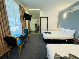 ein Hotelzimmer mit 2 Betten, einem Tisch und Stühlen in der Unterkunft Motel St Arnaud in Saint Arnaud