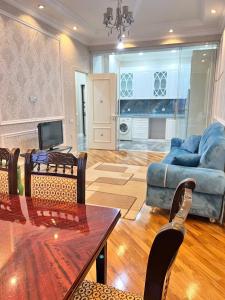 uma sala de estar com uma mesa e um sofá em London House Apartment em Baku