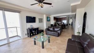a living room with leather furniture and a ceiling fan at Beautiful Beach Front Condo near Downtown in Rosarito