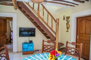 uma sala de jantar com uma escada de madeira e uma mesa em Charming 1-Bed Cottage in Diani Beach 10min to bea em Diani Beach