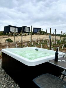- une baignoire avec une table et une bouteille de vin dans l'établissement NUMA Wine Suites, à Ensenada