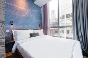 a bedroom with a white bed and a window at Dash Living on Queen's in Hong Kong