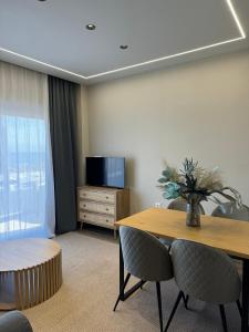 um quarto com uma mesa e cadeiras e uma televisão em Artemis Apartments em Diakopto