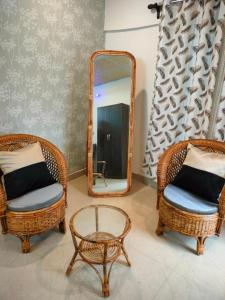 espejo, mesa y 2 sillas de mimbre en Pratishruti en Guwahati