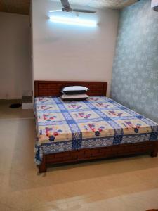 1 dormitorio con 1 cama con edredón en Pratishruti en Guwahati