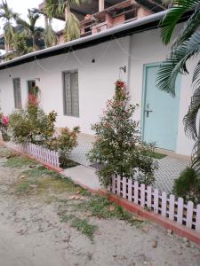 una casa blanca con un árbol de Navidad delante de ella en Pratishruti en Guwahati