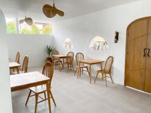un restaurante con mesas y sillas de madera y ventanas en La PAYANA House Penida en Toyapakeh