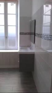 een witte badkamer met een wastafel en een raam bij Appartement centre ville Poitiers in Poitiers