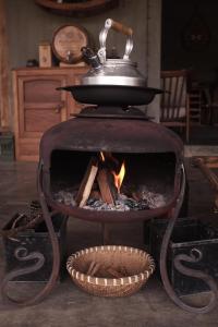 a stove with a pot on top of it with a fire at A Nhà House in Xuân Trường