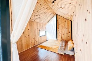 a bedroom with a bed in a wooden room at A Nhà House in Xuân Trường