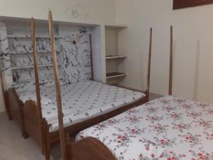 um pequeno quarto com uma cama com colcha floral em Sudha Kutir Puri em Puri