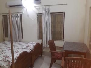 a bedroom with a bed and a table and window at Sudha Kutir Puri in Puri