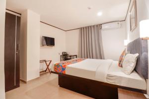 um quarto de hotel com uma cama e uma televisão em FabHotel Park Inn Indiranagar em Bangalore
