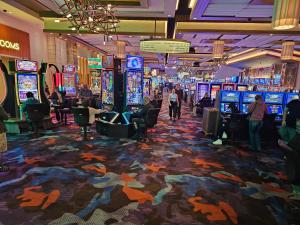 Elegant stay at Palms Strip Las Vegas في لاس فيغاس: كازينو يوجد به اشخاص يلعبون في مكائن القمار
