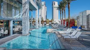 Elegant stay at Palms Strip Las Vegas في لاس فيغاس: مسبح على شكل كراسي والنخيل في مبنى