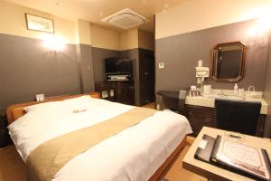 ein Hotelzimmer mit einem Bett und einem Waschbecken in der Unterkunft Hotel Mori no Komichi in Fukuchiyama