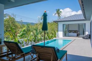 une terrasse avec une piscine, 2 chaises et un parasol dans l'établissement Modern 3 Bedroom Villa! (KBR16), à Koh Samui 