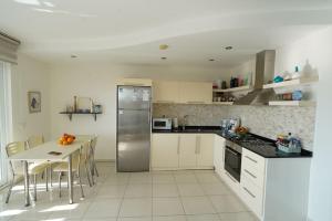 a kitchen with a table and a stainless steel refrigerator at Scenic Sea View 2BR Apartment * 5min to Beach in Alanya