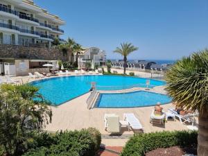 a large swimming pool with lounge chairs and a hotel at Scenic Sea View 2BR Apartment * 5min to Beach in Alanya
