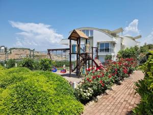 a playground in front of a house with flowers at Scenic Sea View 2BR Apartment * 5min to Beach in Alanya