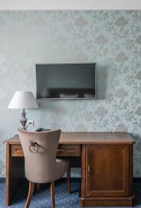 una scrivania con sedia e una TV appesa a un muro di Dworek Komorno a Komorno
