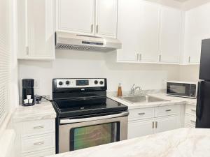 a kitchen with white cabinets and a stove top oven at 2-BDRM Fort Lauderdale - Las Olas Beach 5 minutes walk #5 in Fort Lauderdale