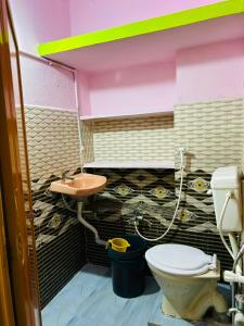 a bathroom with a toilet and a sink at Hotel R residence in Srīsailam