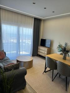 a living room with a couch and a table and a television at Artemis Apartments in Diakopto