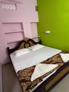 een slaapkamer met een bed met een groene muur bij Hotel R residence in Srīsailam