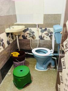 a bathroom with a blue toilet and a sink at Hotel R residence in Srīsailam