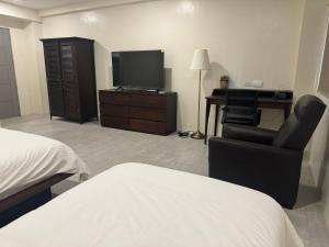 a bedroom with a bed and a desk and a television at Hotel Lucca in Legazpi