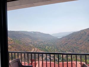 een kamer met een balkon met uitzicht op een vallei bij Western Valley Cottages , Panchagani in Panchgani