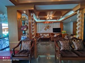 程逸府Areena Resort and Hotel Uttaradit的客厅配有椅子、沙发和电视