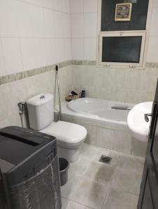 a bathroom with a toilet and a tub and a sink at ZED Hostel (Mix Share Studio) in Abu Dhabi